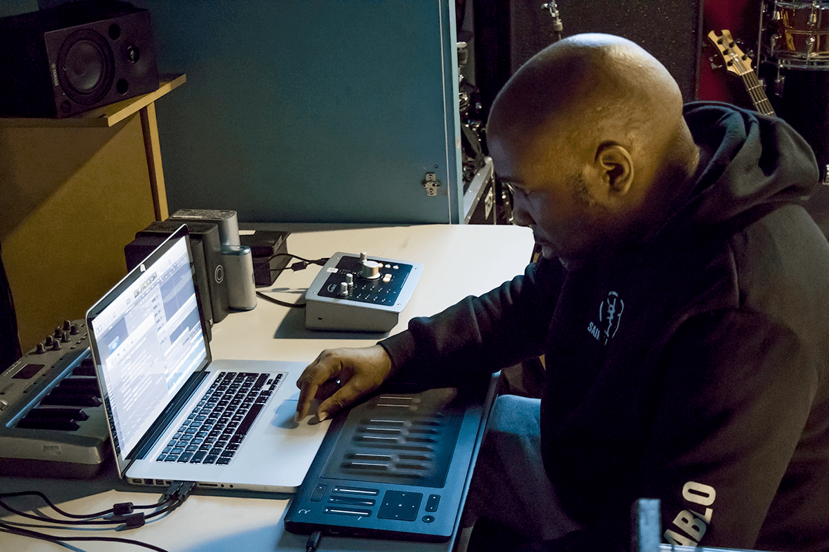 Chris Brown producing on a laptop in his studio